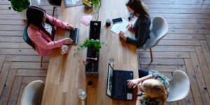 Women around office table finalizing strategic facility plan