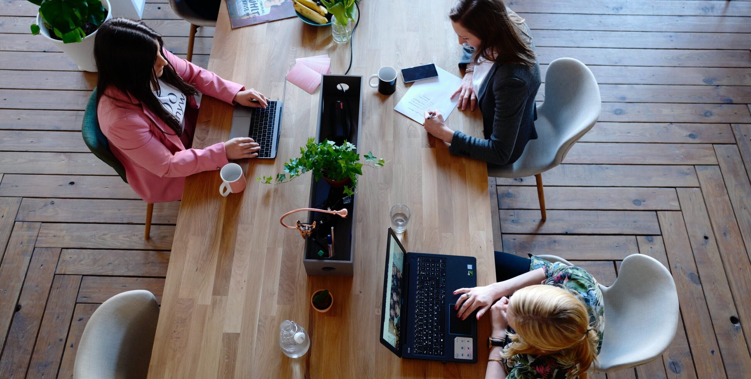 Women around office table finalizing strategic facility plan
