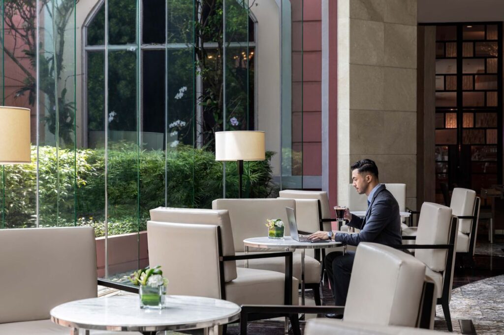 Businessman in corporate office lobby looking at facility management designs in office lobby