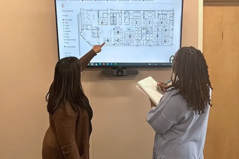 HF Planners staff CAFM planning with client around big screen reading notes