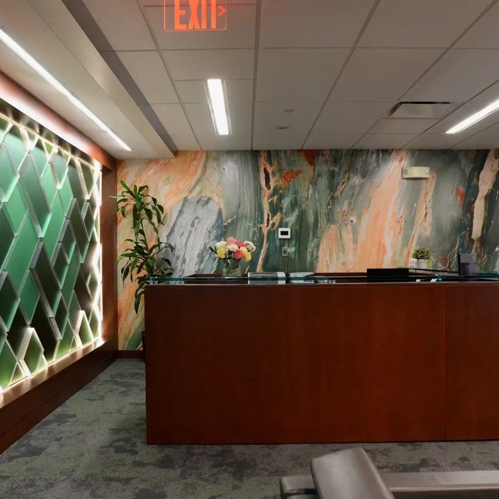 Reception area in corporate office space with brown desk and mural behind